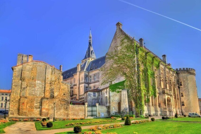A historic building with a prominent tower, a large courtyard, and a well-maintained garden. 4