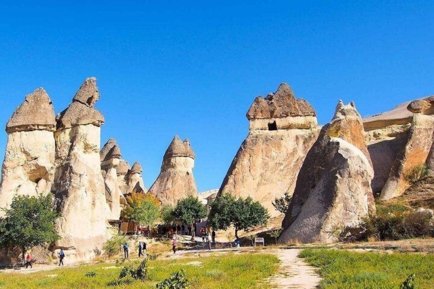A landscape with distinctive rock formations, a clear sky, and a pathway. 3