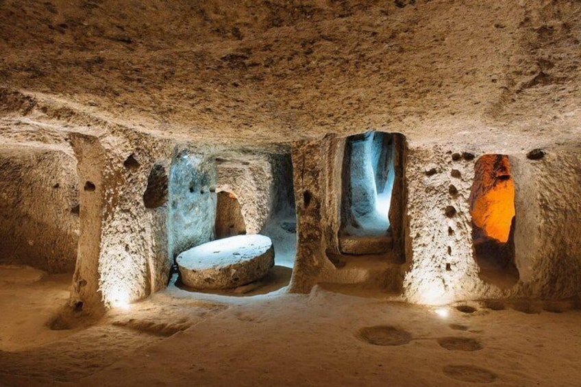 An underground chamber with circular stone structures and a central stone basin. 4