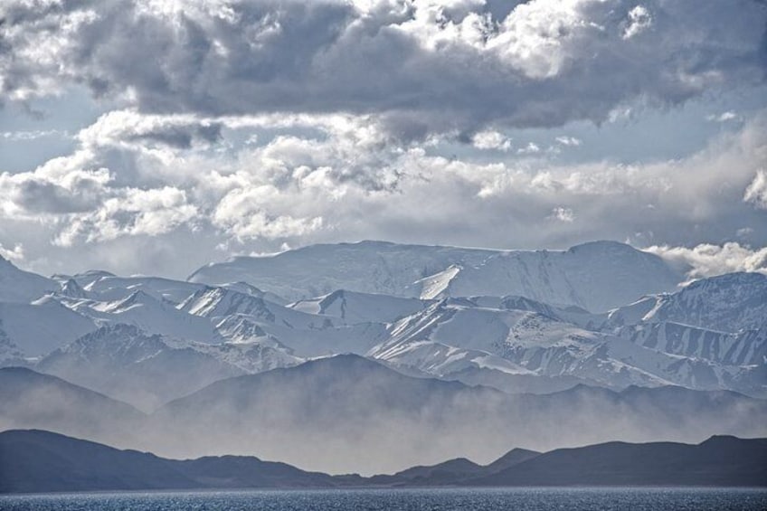 Snow-covered mountains, a lake, and a cloudy sky. 3