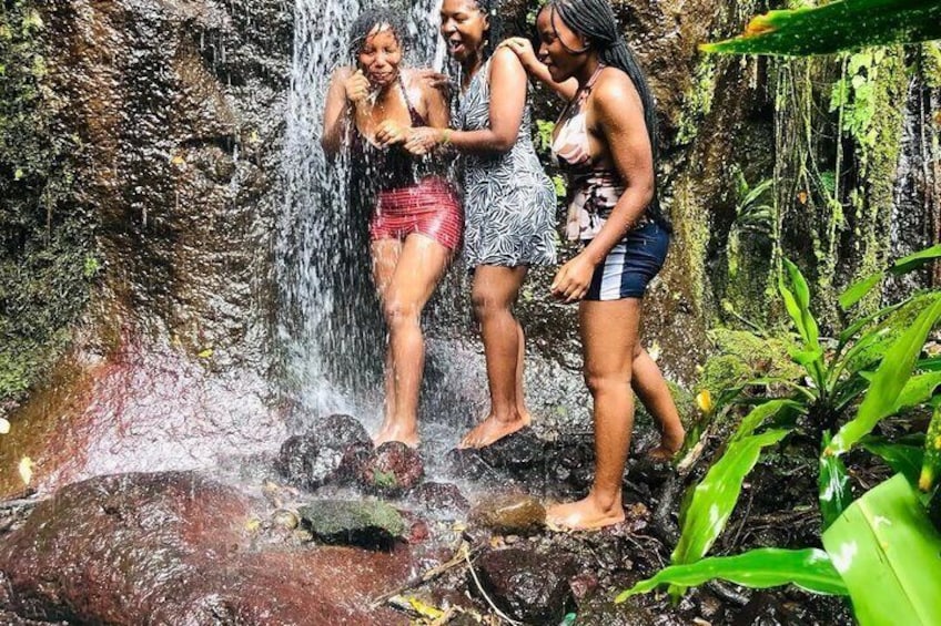 A waterfall with people standing on rocks. 2