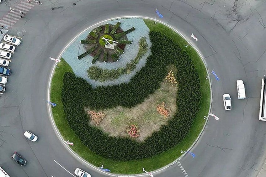 A roundabout with a central landscaped area, surrounded by roads with cars. 4
