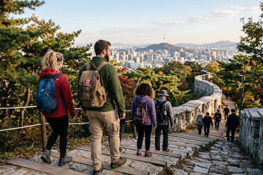 A group of hikers on a stone staircase with a cityscape in the background. 4