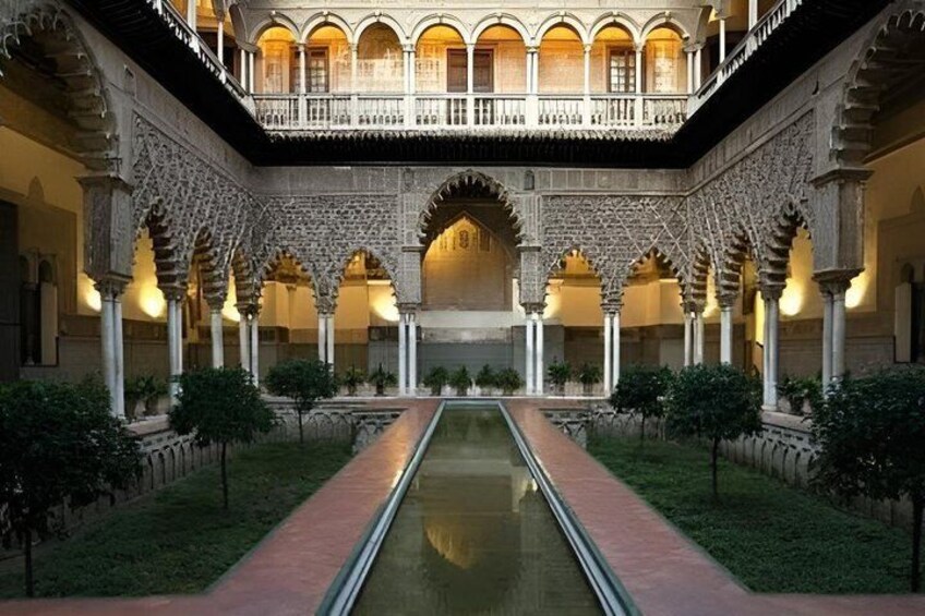 A courtyard with a central water feature, arches, and a balcony overlooking the space. 1
