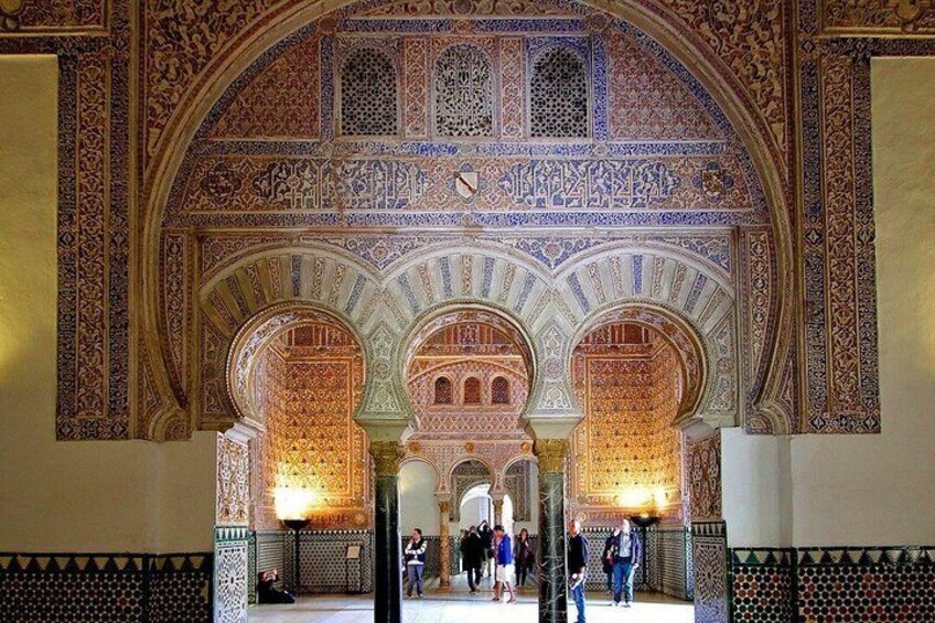 An ornate archway with intricate tile work and a series of arches leading into a courtyard. 2