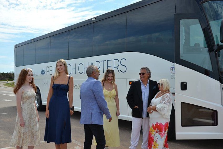 A group of people standing in front of a charter bus with 'PEACH CHARTERS' written on it. 4