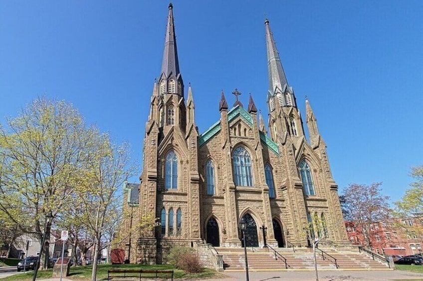 A large Gothic-style church with two tall spires, a green roof, and a large arched entrance. 4