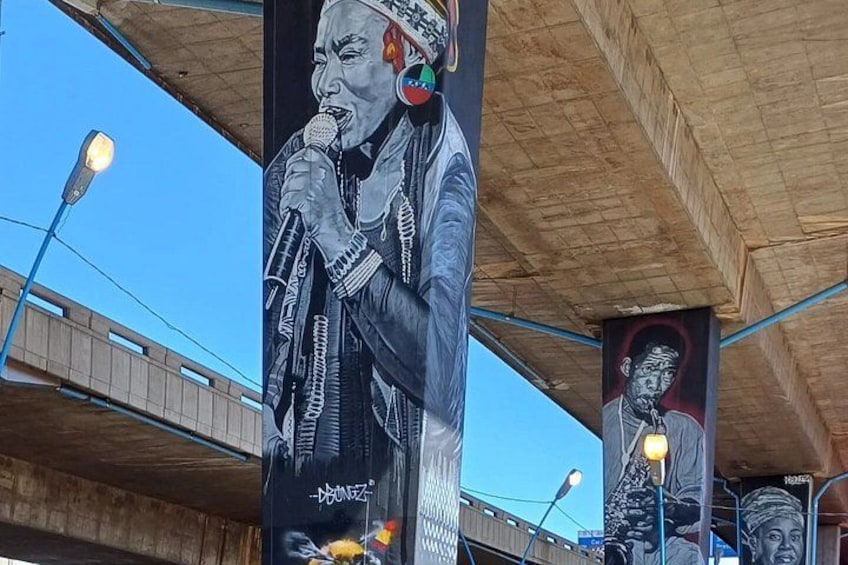A mural of a person singing on a building. 3