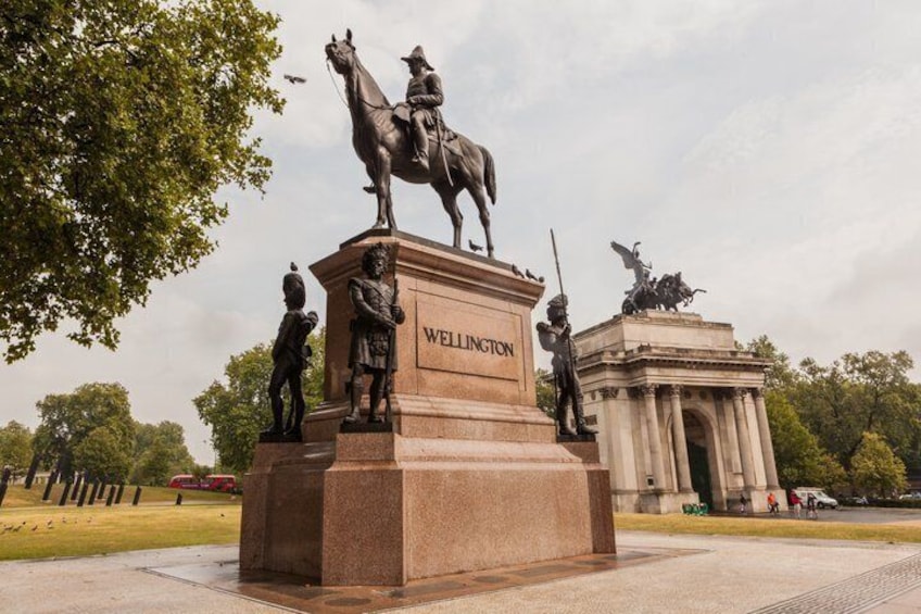 A statue of a mounted figure with a horse, labeled 'WELLINGTON,' and a building in the background. 3