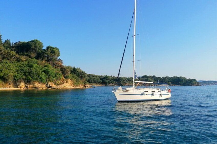 A sailboat on calm waters with a forested coastline in the background. 5