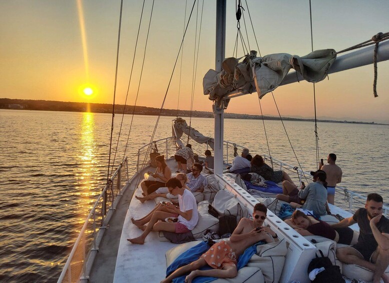 A boat with people relaxing during sunset. 5
