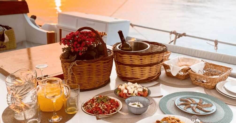 A table set with various dishes, drinks, and baskets on a boat. 2