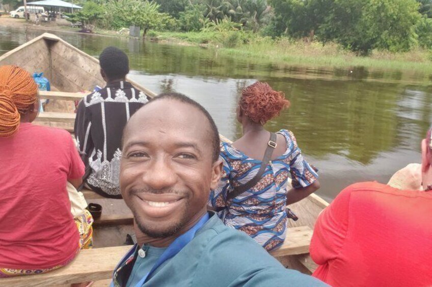 A group of people on a wooden boat on a calm river surrounded by greenery. 2