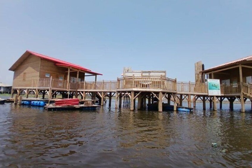 Wooden structures on stilts over water, connected by a bridge. 5