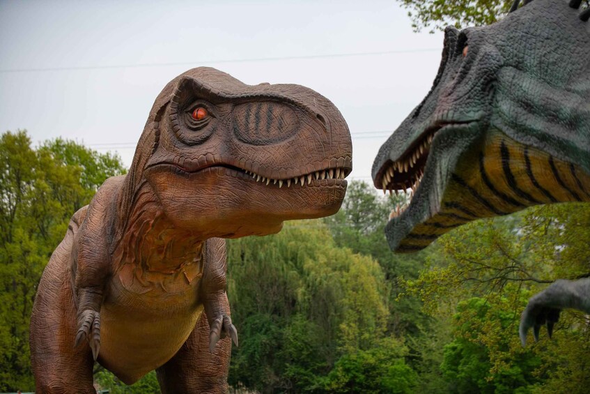 Two dinosaur statues in a natural setting. 1
