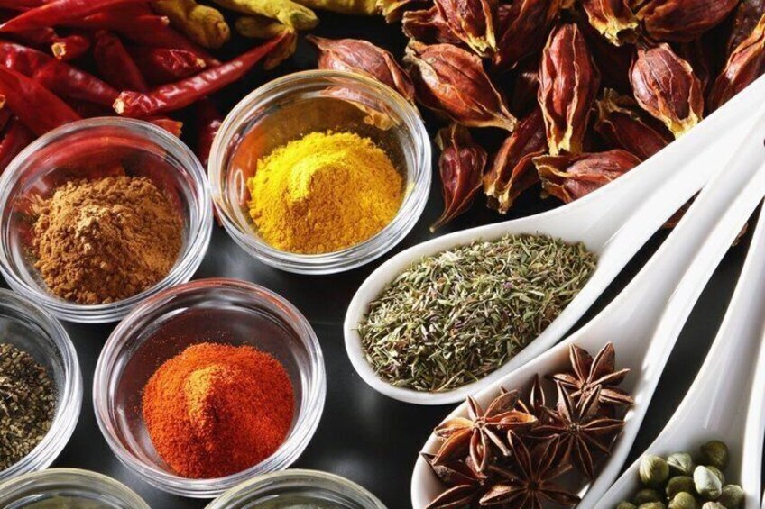 Various spices and dried herbs in glass containers and on spoons. 3