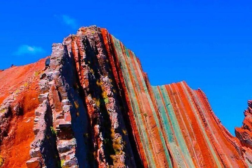 A rugged cliff with vertical striations in red and green hues. 2