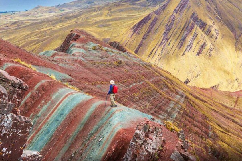 Un excursionista en una cresta montañosa de colores y rayas. 2