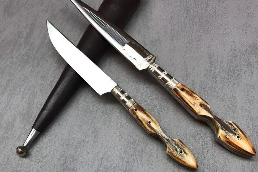 A knife with a black handle and a wooden handle with a fish design. 2