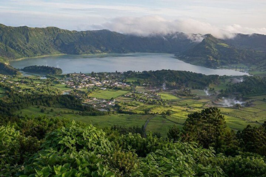 A lake surrounded by mountains, a small town, and lush greenery. 5