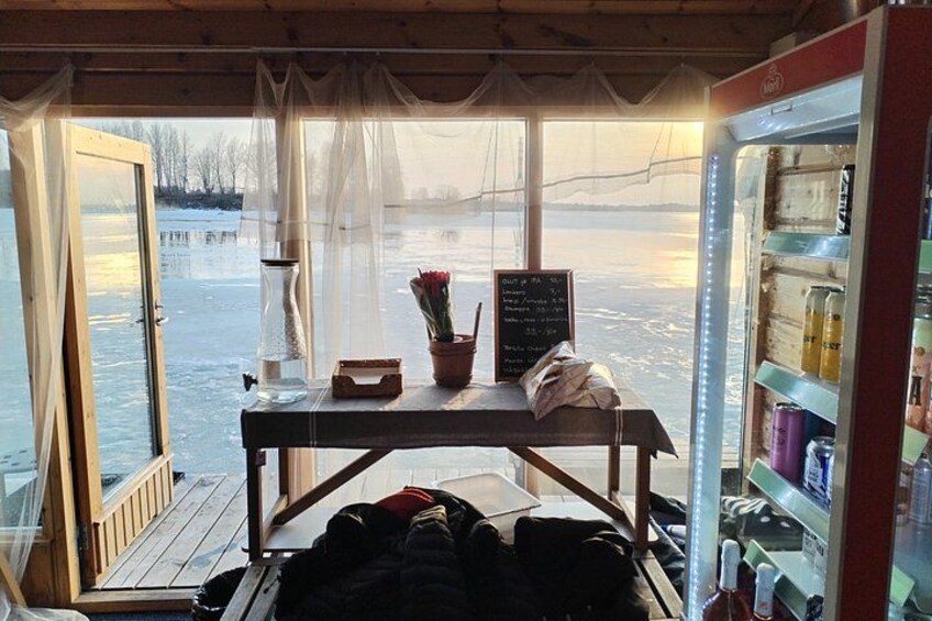 A wooden table with a chalkboard menu, a vase with red flowers, and a glass jar. 5