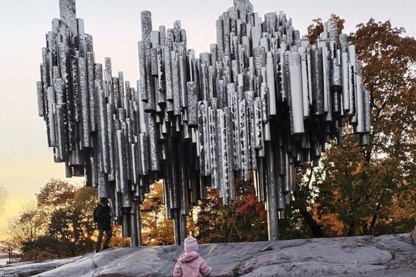 A sculpture of vertical, cylindrical shapes in a park. 1