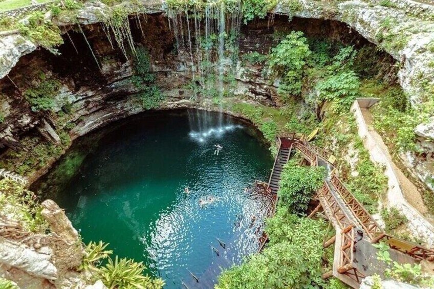 A natural pool with a wooden walkway and a waterfall. 5