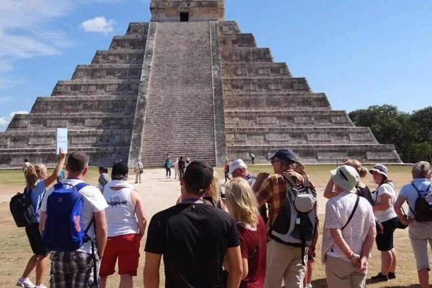 A large pyramid with tourists observing it. 1