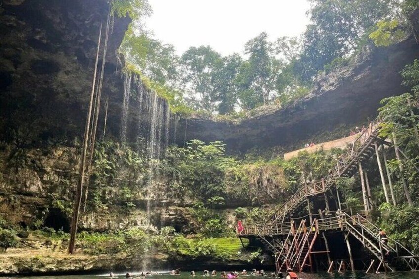 A natural waterfall, a wooden bridge, and a forested area. 3