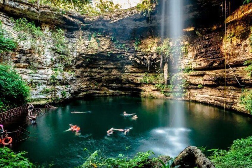 A natural pool with a waterfall, surrounded by greenery and rocky cliffs. 2