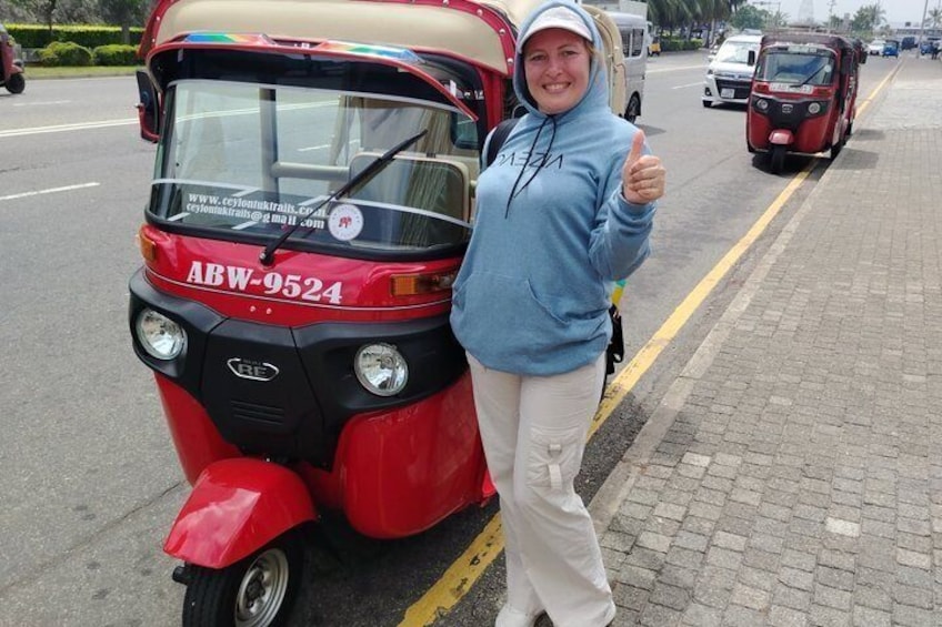 A red auto-rickshaw with the license plate ABW-9524 parked on a paved road. 4