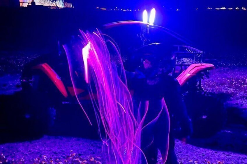 A vehicle with purple light trails and a person standing beside it. 4