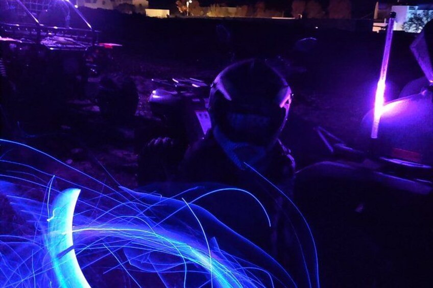 A person in a dark setting with blue light trails. 3