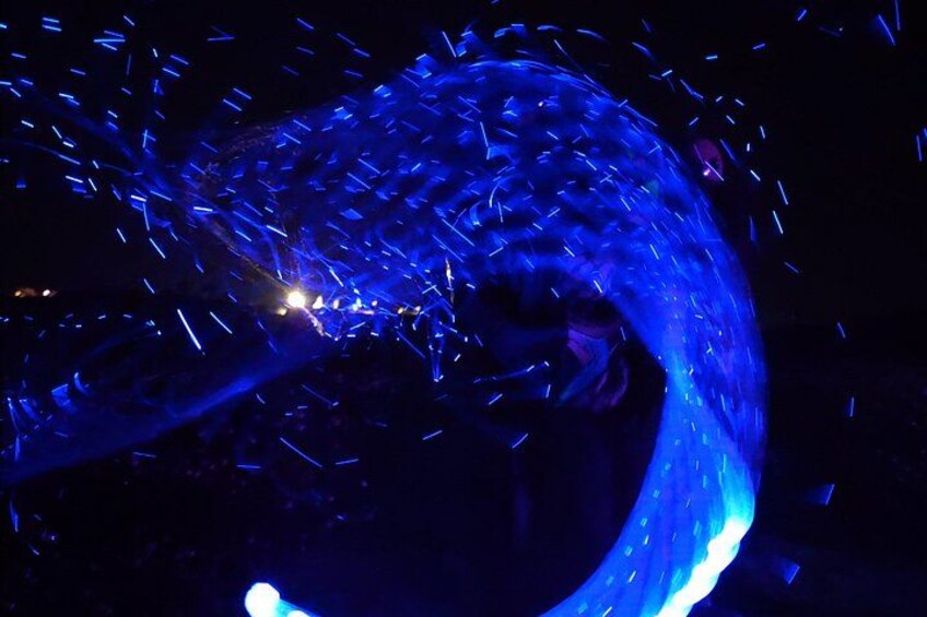 A person performing a fire-breathing act with sparks flying. 2