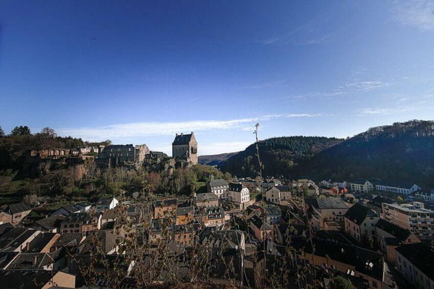 A town with a prominent church on a hill, surrounded by residential buildings and a hilly landscape. 5