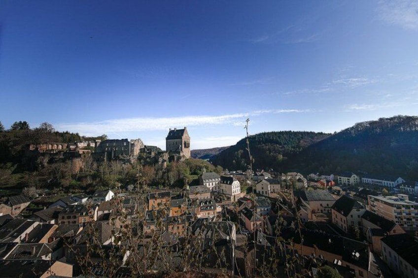 A town with a prominent church on a hill, surrounded by residential buildings and a hilly landscape. 5