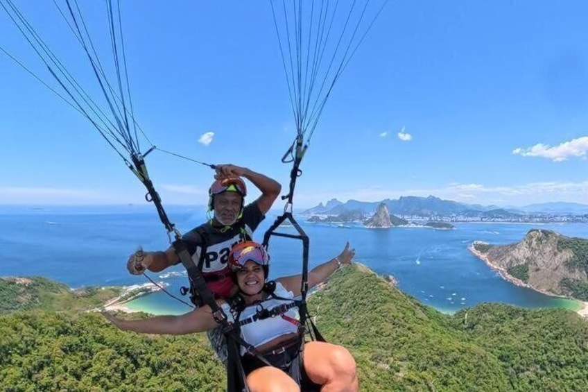 A person paragliding with a harness and a parachute, overlooking a coastal landscape with cliffs and a body of water. 4