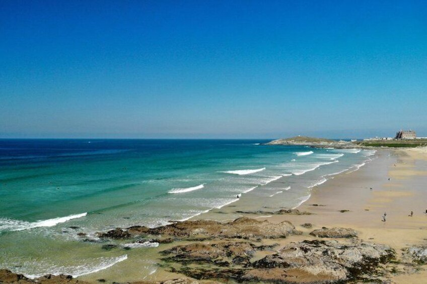 A beach with clear turquoise water, a sandy shore, and a distant building. 3