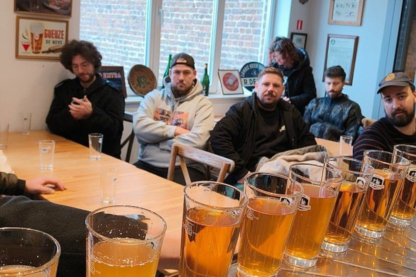 A group of people sitting at a table with multiple glasses of beer. 1