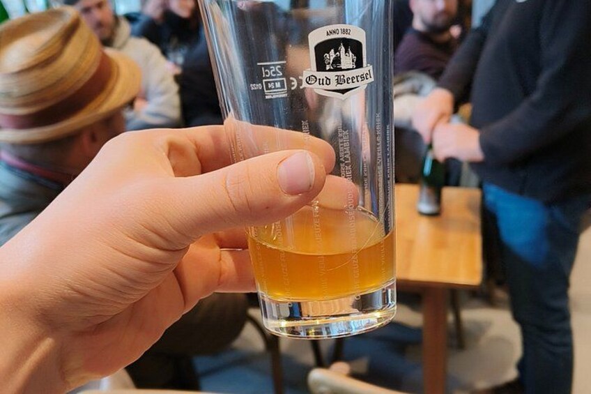 A hand holding a glass of beer with a label reading 'Oud Beersel.' 2
