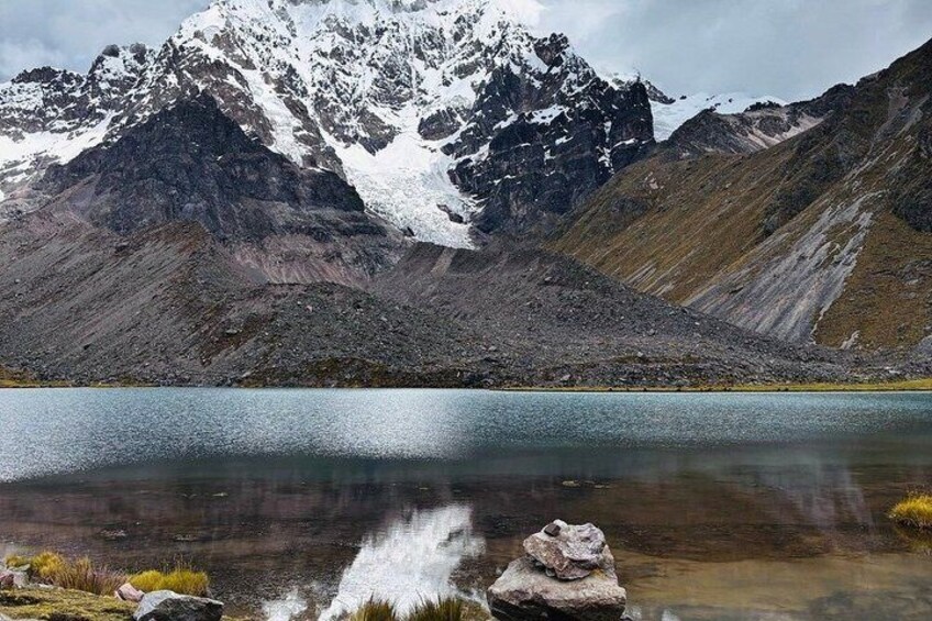 A mountain lake with clear water, rocky shore, and snow-capped peaks. 2