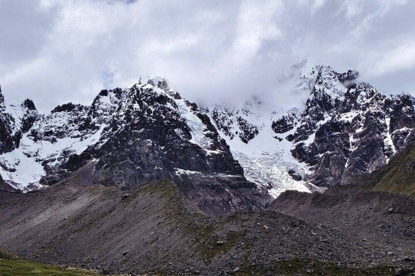 A rugged mountain landscape with snow-capped peaks and rocky terrain. 1