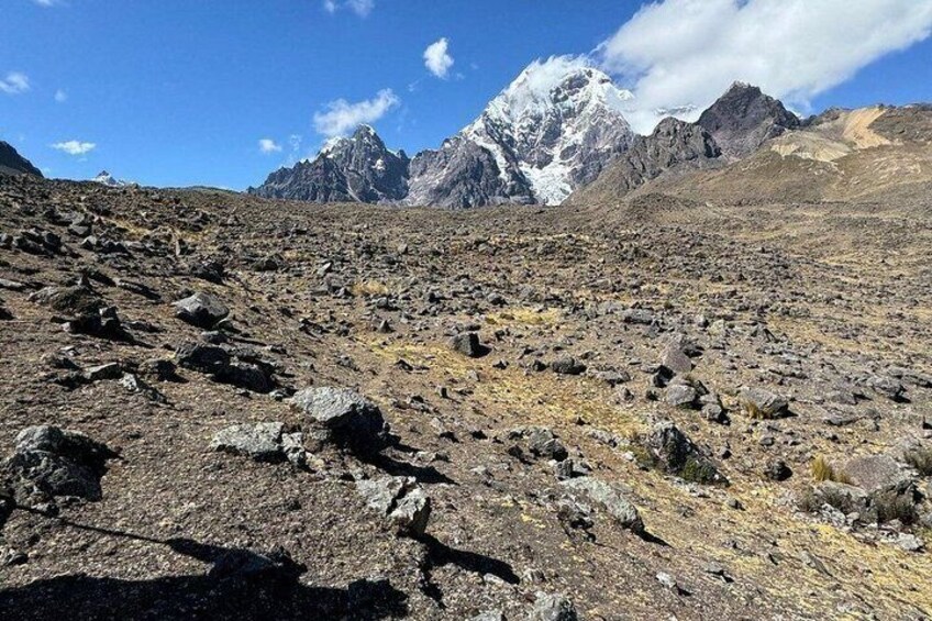 A rocky mountain terrain with snow-capped peaks in the distance. 5
