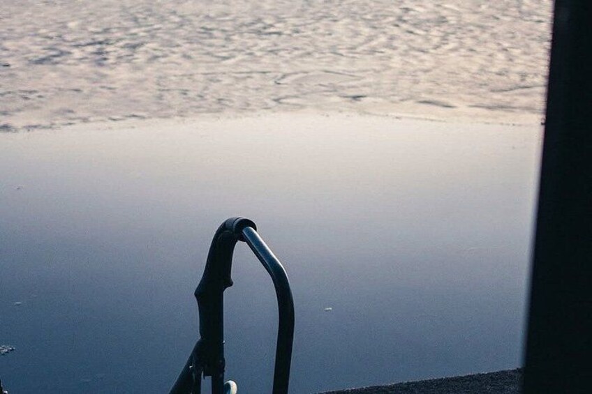 A metal structure, possibly a part of a boat or dock, with a reflective surface in the background. 5