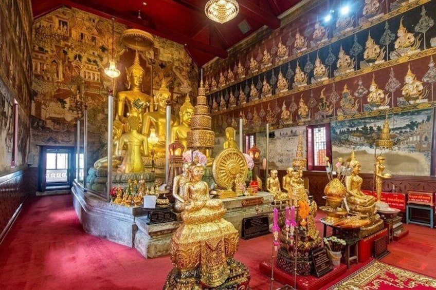 A temple interior with golden statues and intricate wall carvings. 5