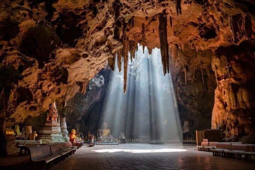 A cave with stalactites, a central altar, and benches. 1