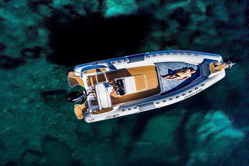 A boat with a person lying on the deck, surrounded by clear water. 5
