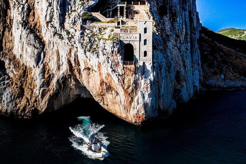 A boat near a cliff with a building labeled 'LAVIA' on top. 4
