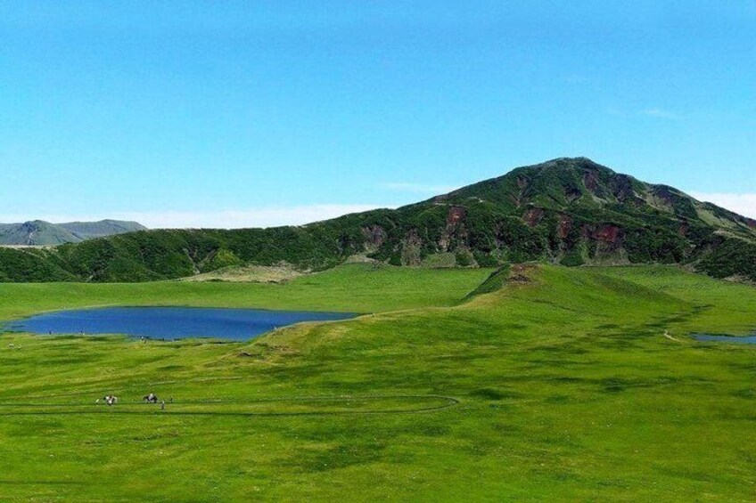 A mountain, a lake, and a grassy field. 5