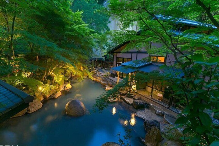 A serene Japanese garden with a koi pond, rocks, and traditional buildings. 1